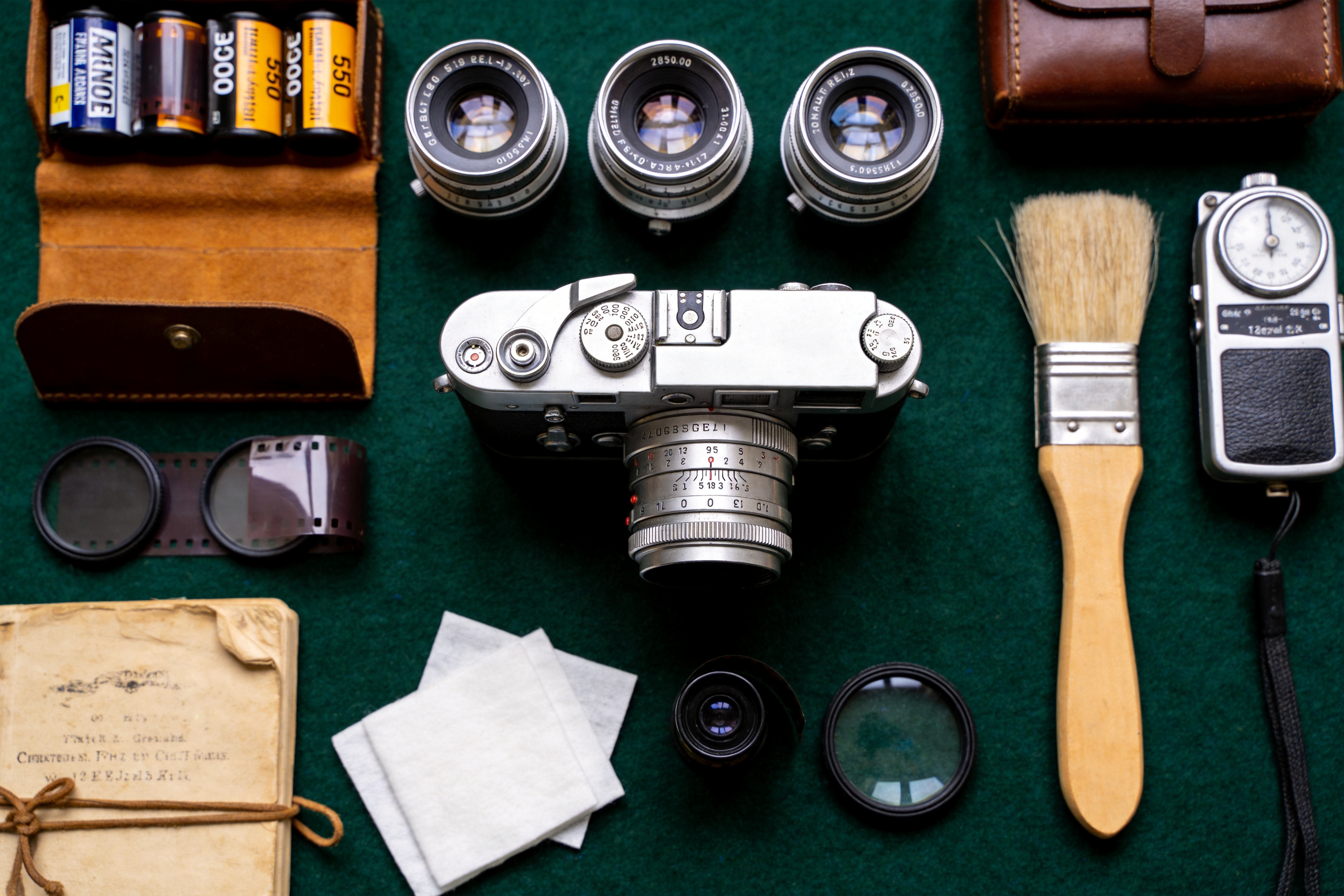 Overhead 4K knolling photograph of vintage camera gear arranged in a grid on green felt