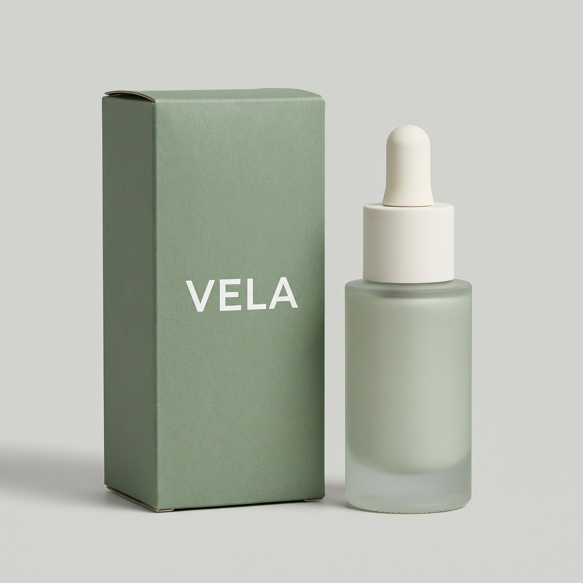 Sage-green box with the brand name VELA next to a matching frosted glass bottle