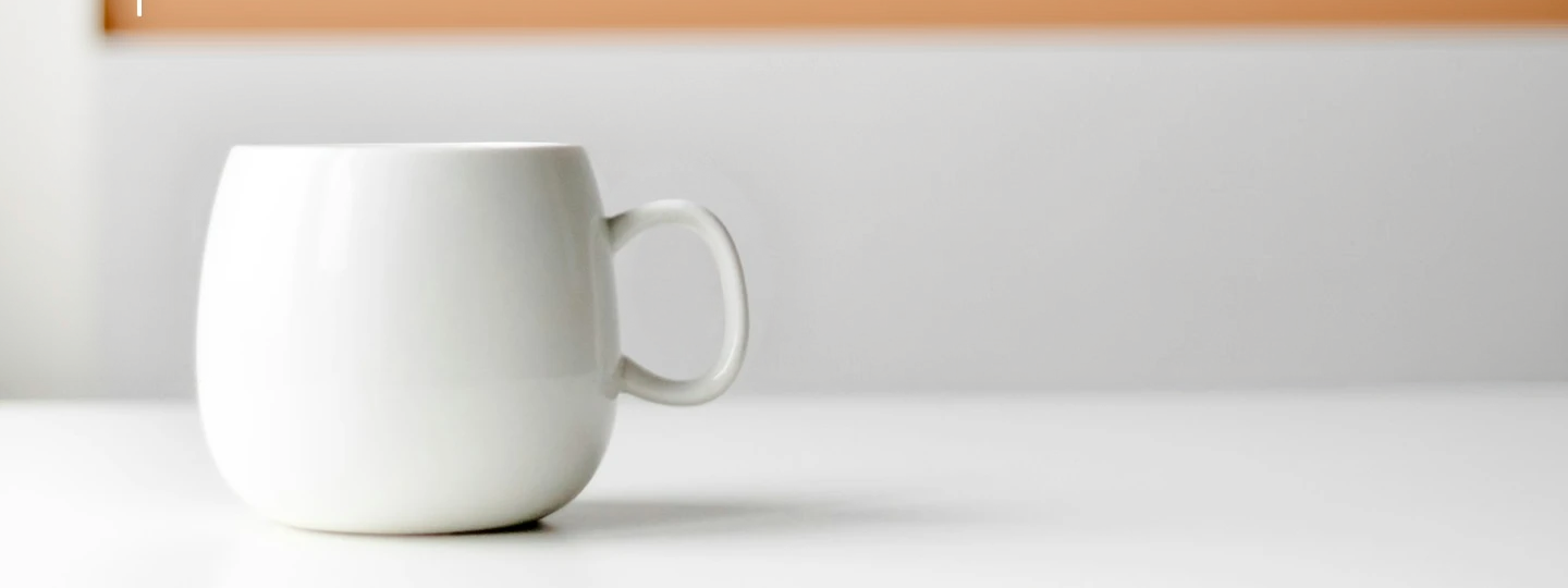 Output: the white wall behind the mug becomes a warm terracotta studio backdrop with a soft gradient